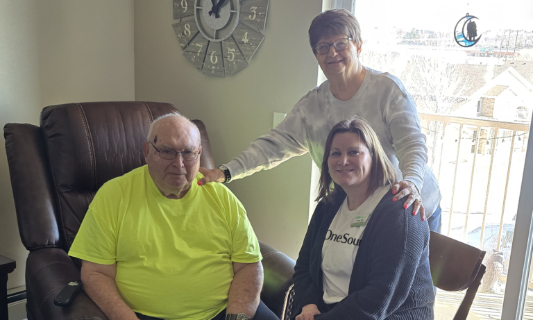 female nurse sitting with male patient and his family member